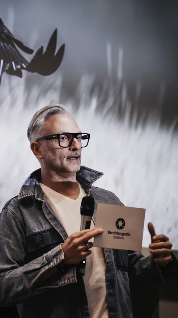 Michael Preschl, Werbefotograf und Visual Brand Specialist aus Salzburg, im Gespräch mit Teilnehmern einer Fachveranstaltung der Salzburger Berufsfotografie. Der Austausch konzentriert sich auf aktuelle Entwicklungen in der professionellen Fotografie und visuellen Kommunikation.