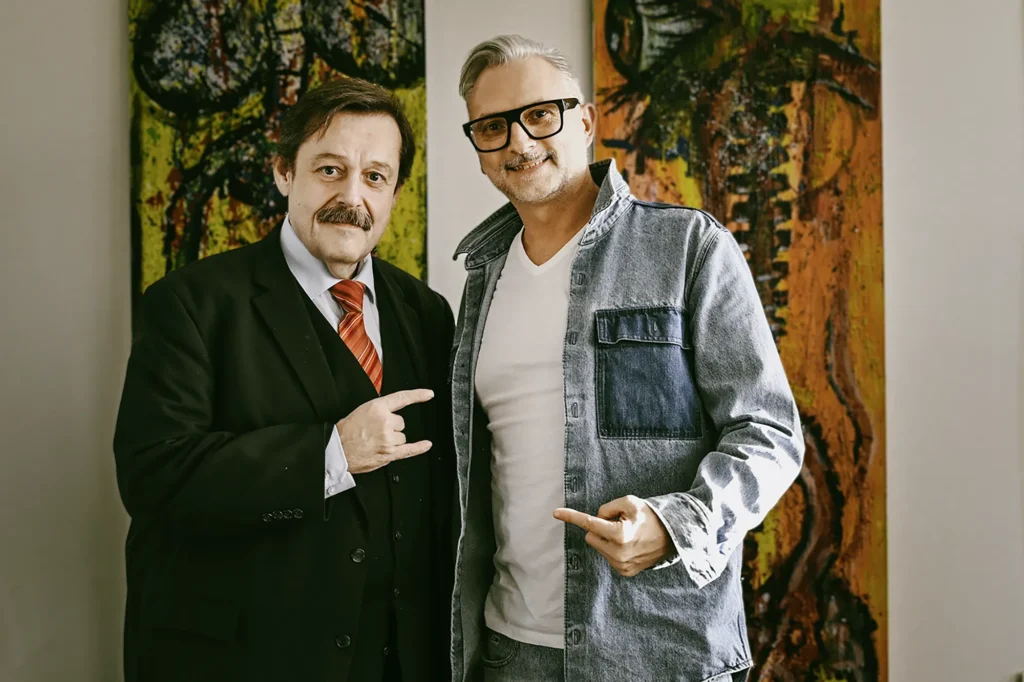 Michael Preschl, Werbefotograf und Visual Brand Specialist aus Salzburg, gemeinsam mit dem österreichischen Physiker, Wissenschaftskabarettisten und Universitätsprofessor Werner Gruber bei einer Veranstaltung. Beide stehen vor einem großformatigen Kunstwerk und präsentieren sich für ein gemeinsames Erinnerungsfoto.