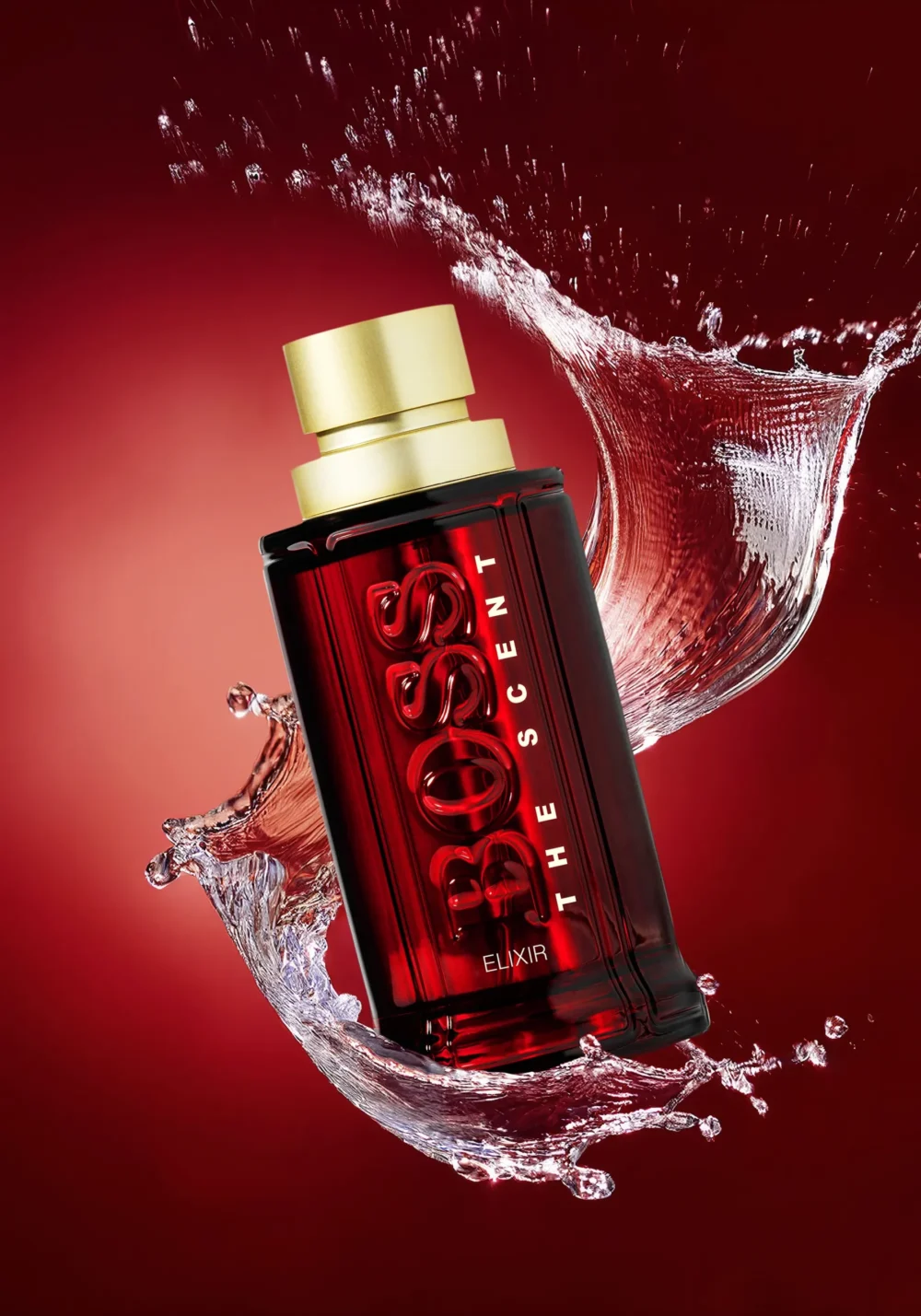 The Scent. Elixir. Hugo Boss — Product Photography by Michael Preschl Hugo Boss The Scent Elixir Parfum in dunkelrotem Glasflacon mit mattem Goldverschluss, von einer dynamischen Wasserspritzwelle umgeben vor rotem Hintergrund – Produktfotografie Kampagne, Fotograf Michael Preschl