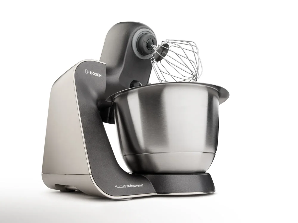Precision meets power. Bosch HomeProfessional — Product Photography by Michael Preschl Bosch HomeProfessional Küchenmaschine in Anthrazit-Silber mit Edelstahlschüssel und Schneebesen-Aufsatz auf weißem Hintergrund, leichte 3/4-Perspektive von vorne-rechts – Produktfotografie Brand Visual, Fotograf Michael Preschl